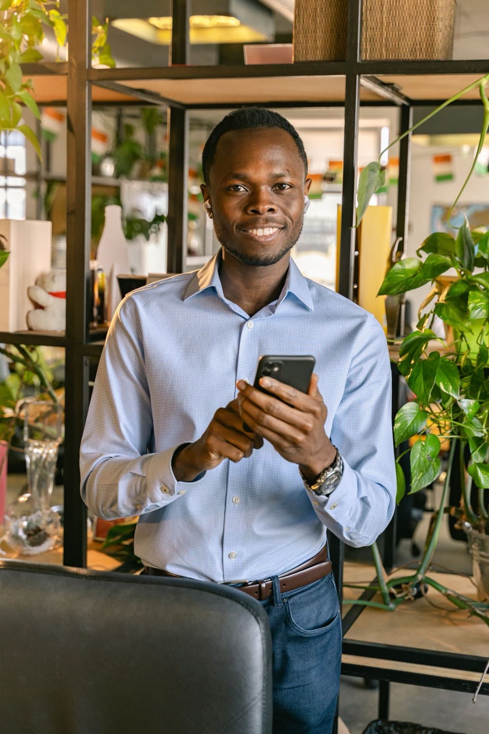 A shop owner smiling at a payment on his phone